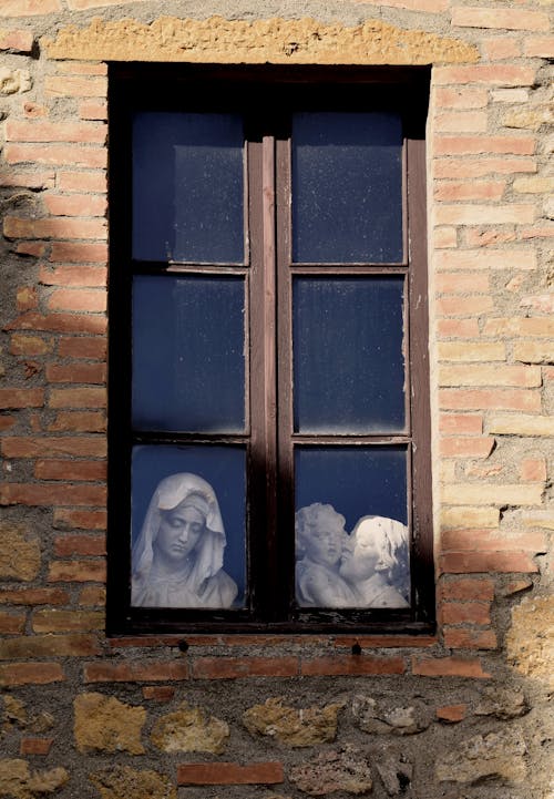 A window with a statue of a woman and child