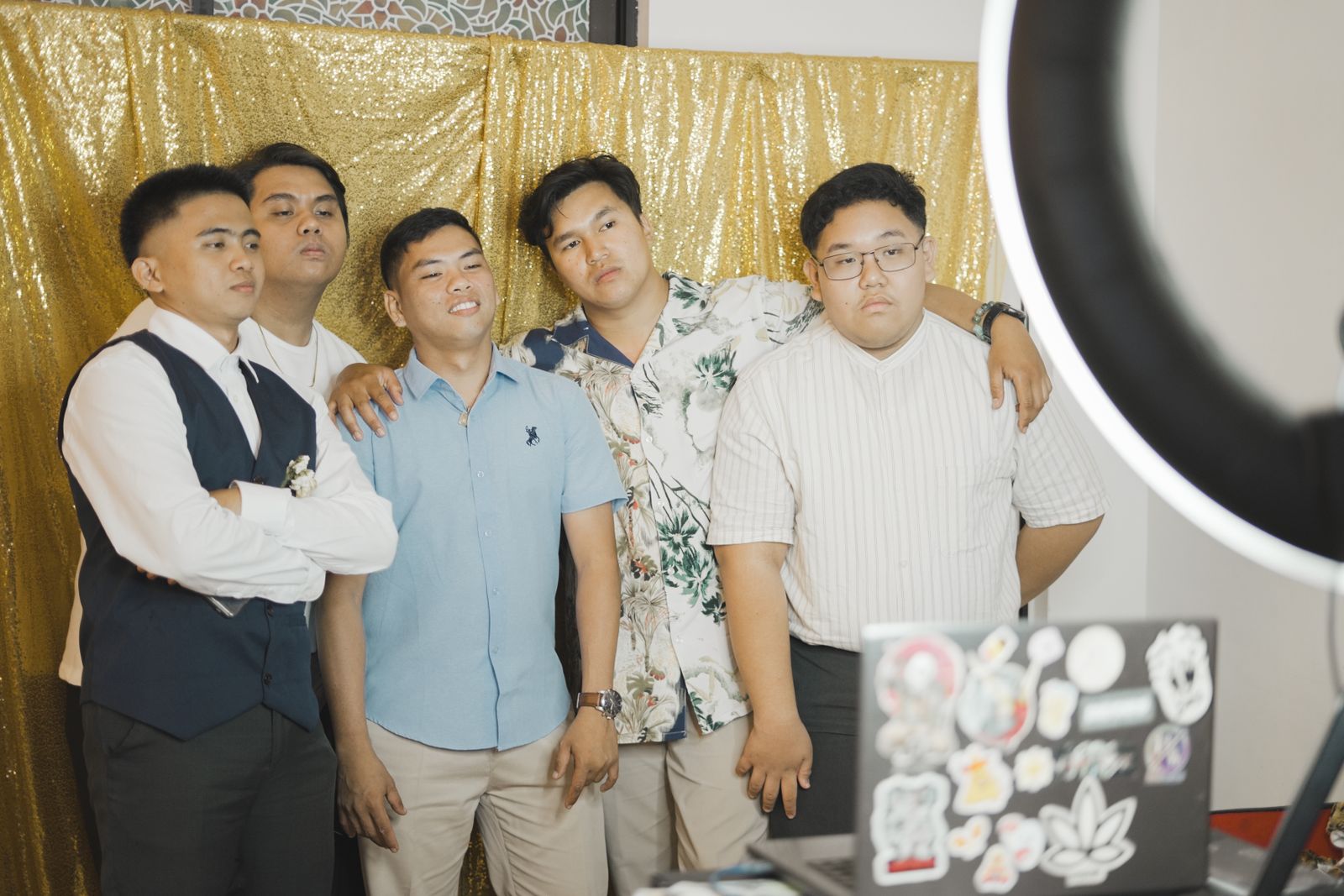 Guests posing in front of a gold sequin booth backdrop