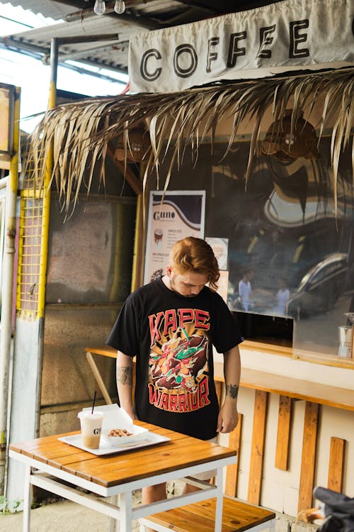 Man Standing behind Table at Cafe