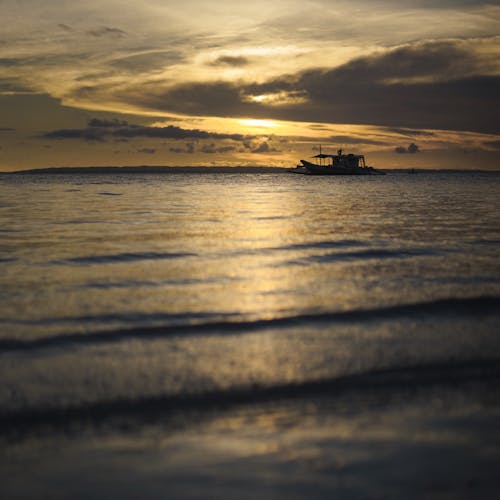 A boat is in the water at sunset