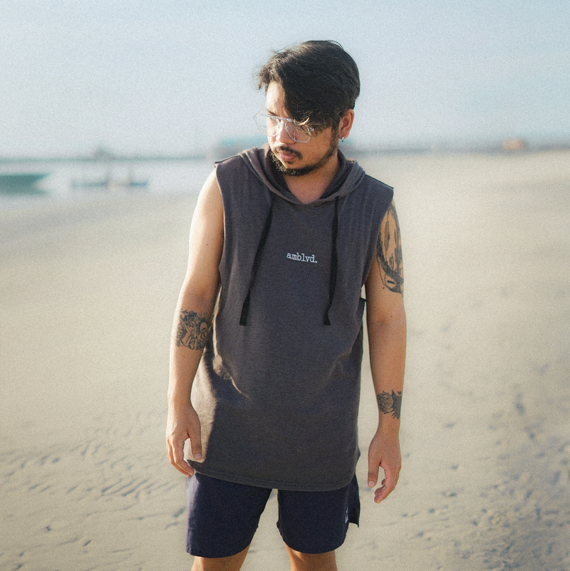 ผู้ชายใส่เสื้อกล้ามและแว่นกันแดดริมทะเล