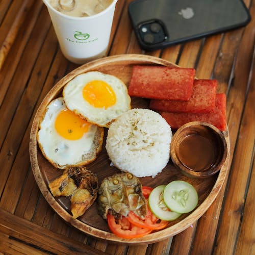 A plate of food with rice, eggs, and vegetables