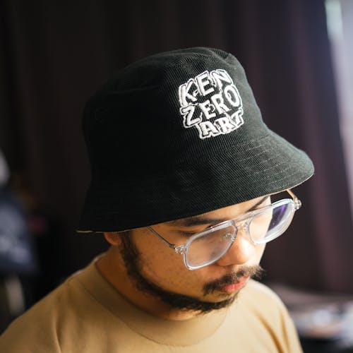 A man wearing a black bucket hat with a logo on it