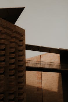 A modern building exterior with a bridge highlighting urban architecture in warm lighting.