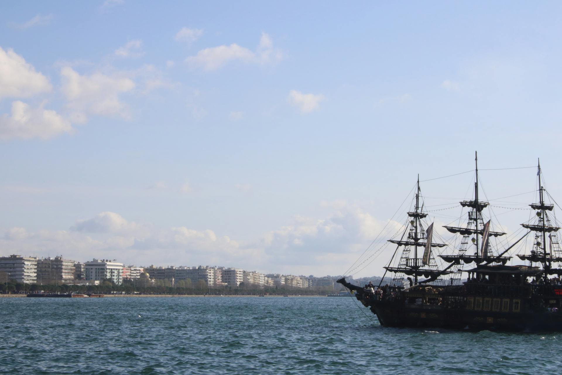 Vintage Ship Sailing with City Buildings behind