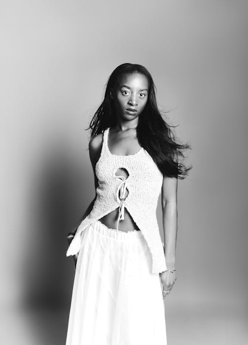 A woman in a white dress posing for a black and white photo