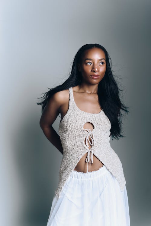 A woman in white skirt and top posing for a photo