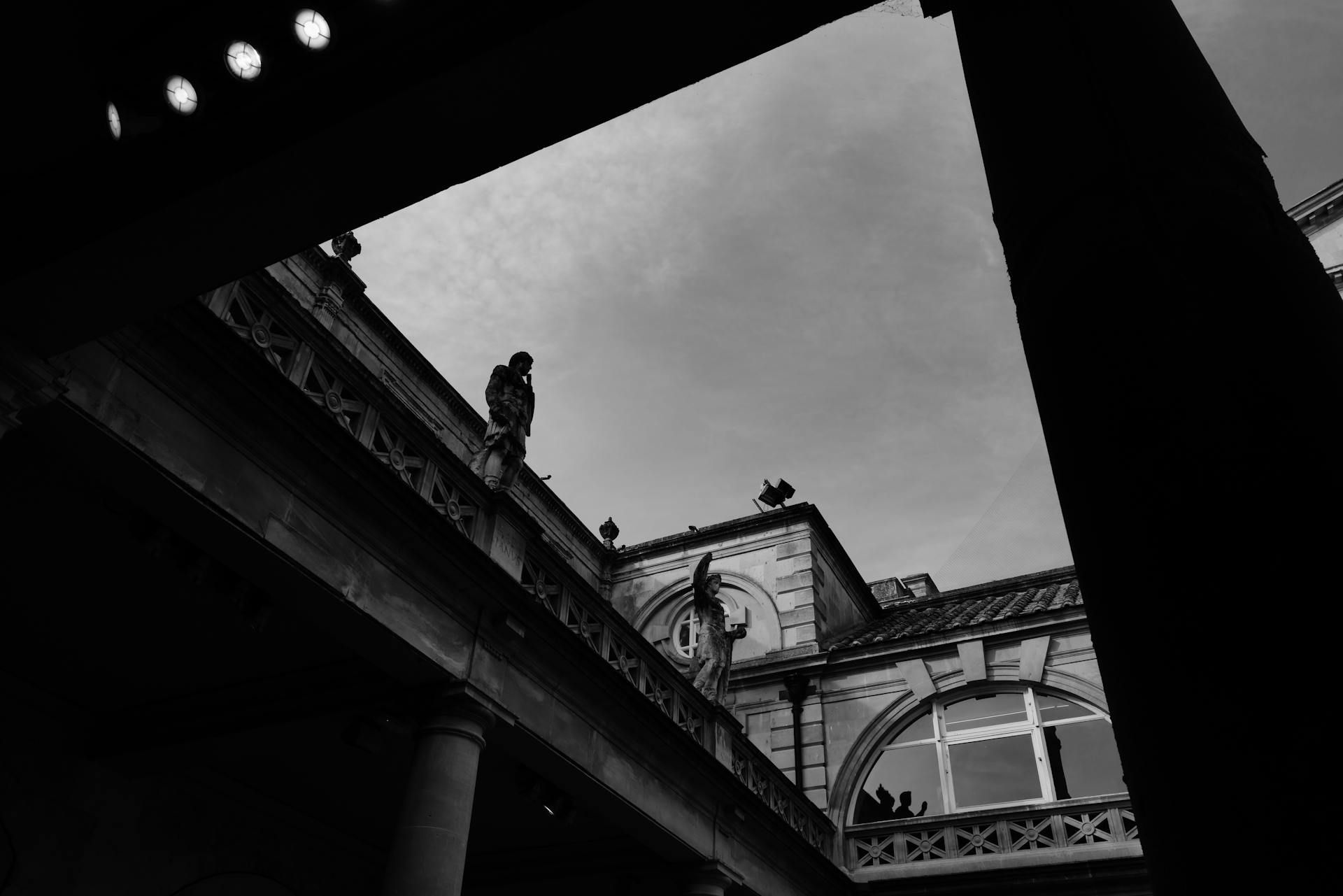 Dramatic black and white silhouette of the Roman Baths architecture in Bath, England.