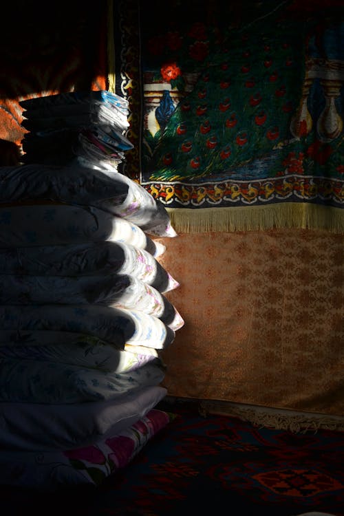 Free A pile of pillows in a room with a window Stock Photo