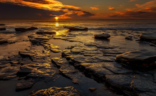 Безкоштовне стокове фото на тему «берег моря, Захід сонця, камені»