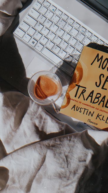 Cozy workspace featuring a coffee cup, book, and keyboard, creating a relaxed atmosphere.