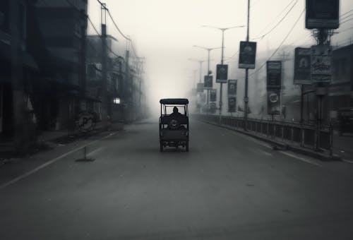 A black and white photo of a car driving down a street