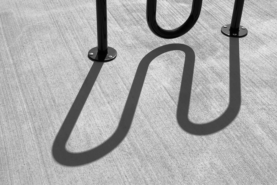 Artistic black and white photo of metal shadows on pavement, captured in Ocala, FL.