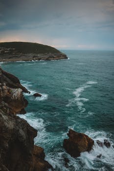 A breathtaking view of the rugged coastline and ocean waves in Llanes, Spain.