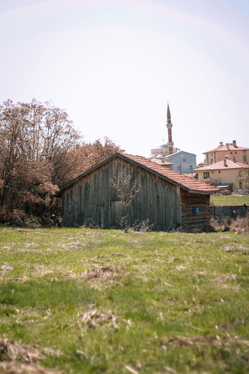 A small wooden building in the middle of a field