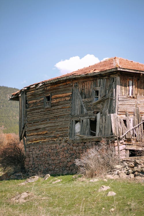 An old wooden house with a roof that is falling down