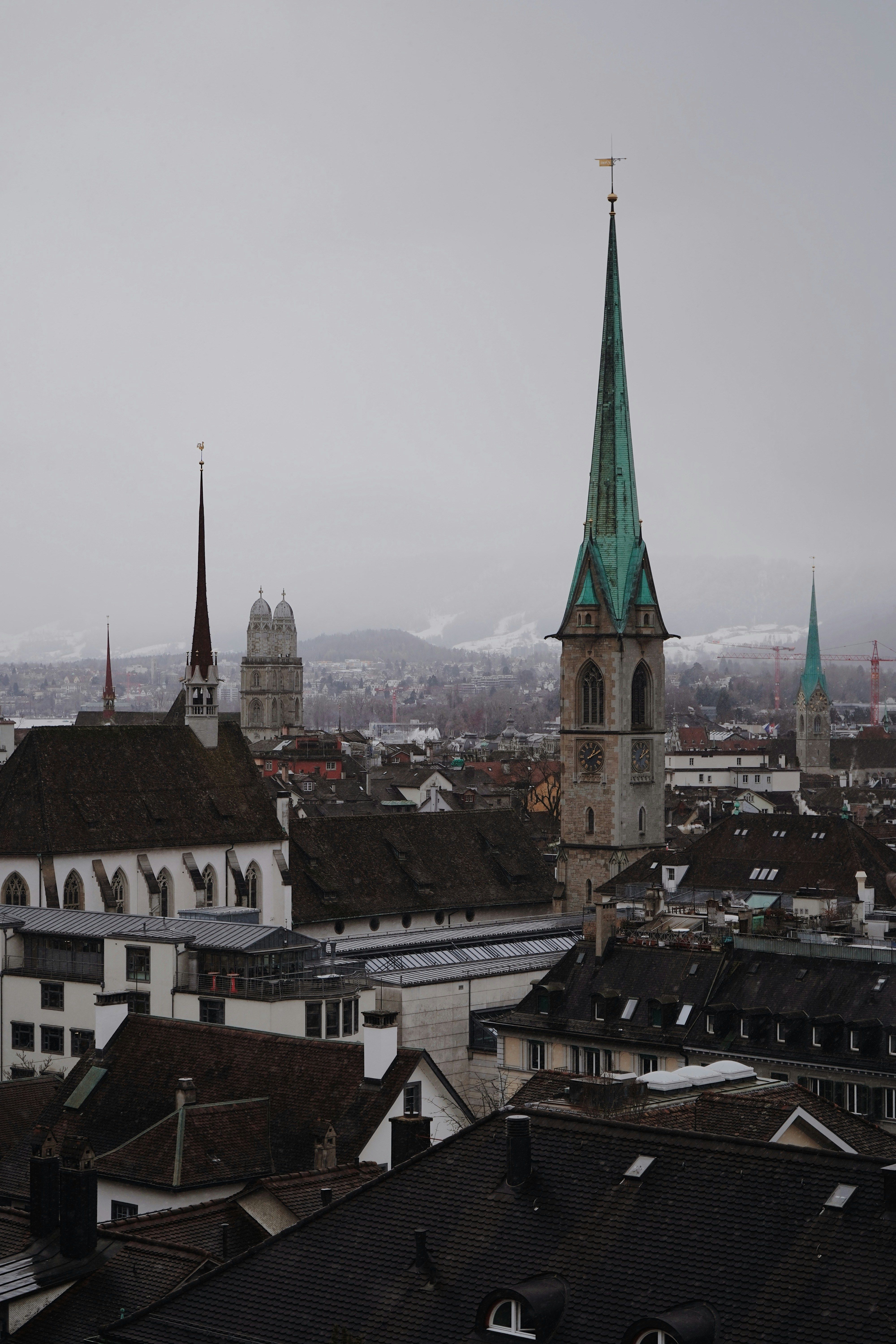 Panoramic view of Zurich's historic churches and rooftops on a foggy day.