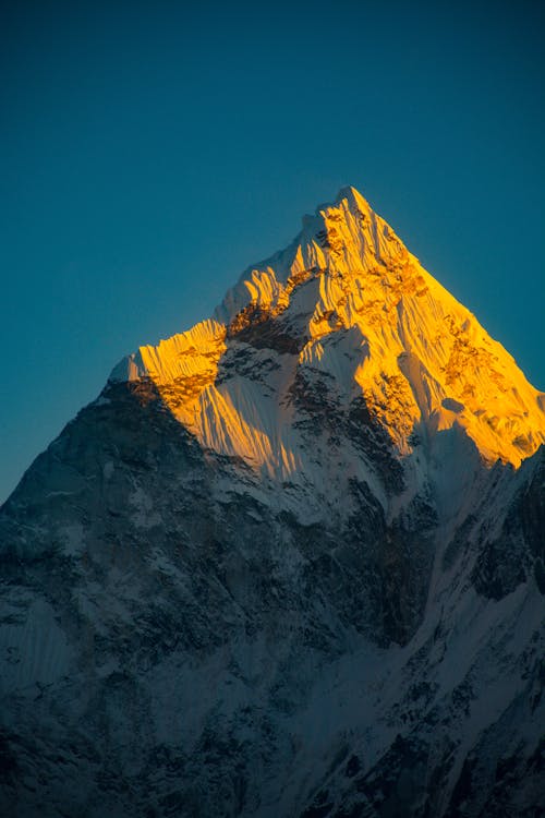 A mountain peak is illuminated by the sun