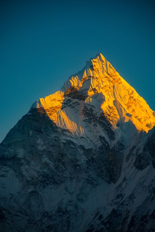 Free A stunning peak glowing in golden sunset light, capturing serene mountain beauty. Stock Photo