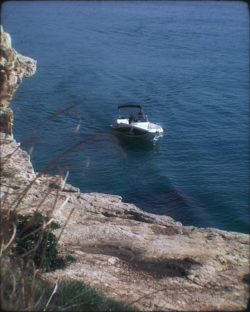 A boat is in the water near a cliff