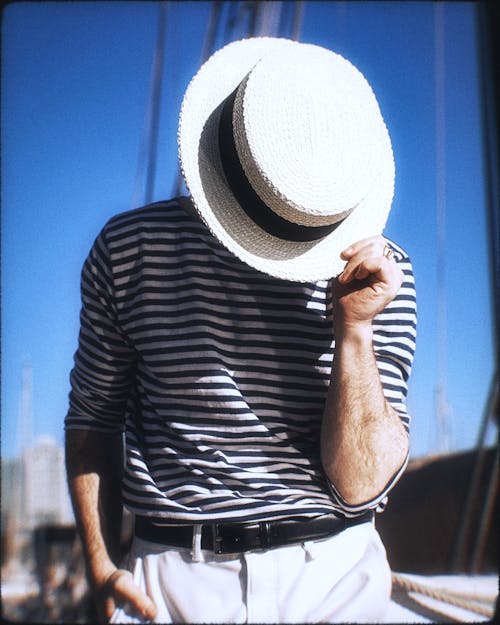 Man in Striped Sweater Holding Hat