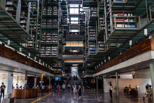 Spacious library interior showcasing modern architecture with people exploring the book-filled space.