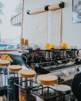 Sleek coffee machine in a Bangkok café with tropical vibes and coffee jars.