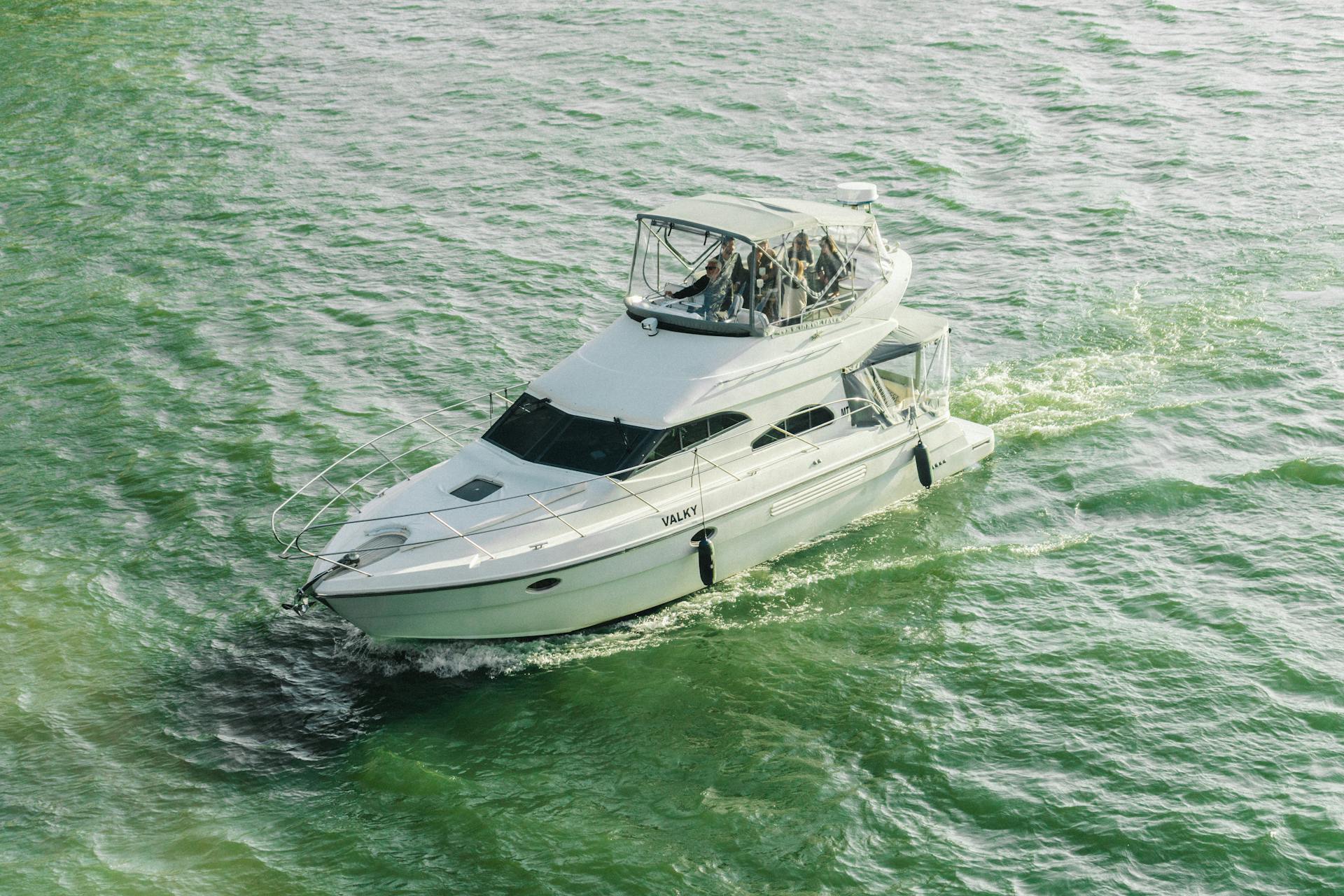 A white yacht cruises through the green waters of Porto, Portugal, offering a leisure travel experience.