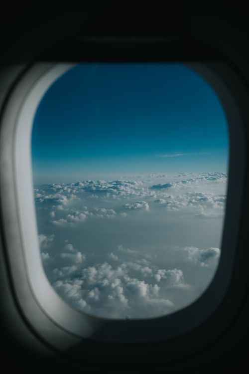 Free Serene view of fluffy clouds and blue sky from an airplane window over Bangkok. Stock Photo