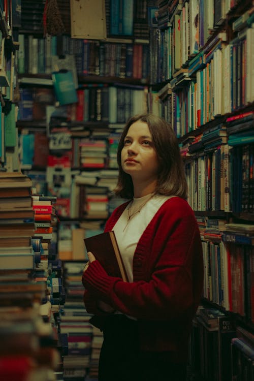 A girl standing in a library with books