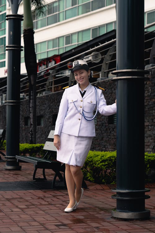 A woman in a white uniform standing on a street corner
