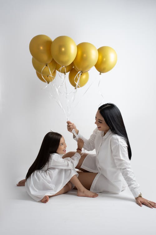 A woman and her daughter holding balloons
