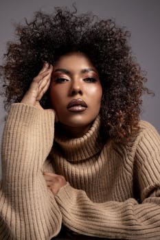 Close-up portrait of a woman in a cozy turtleneck sweater with a striking curly hairstyle.