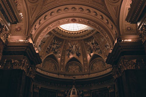 The ceiling of a church with a dome and a clock