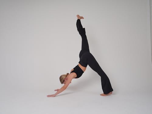 A woman doing a yoga pose on a white background