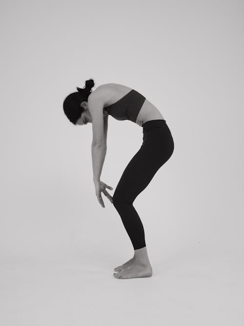 A woman in a black and white photo doing a yoga pose