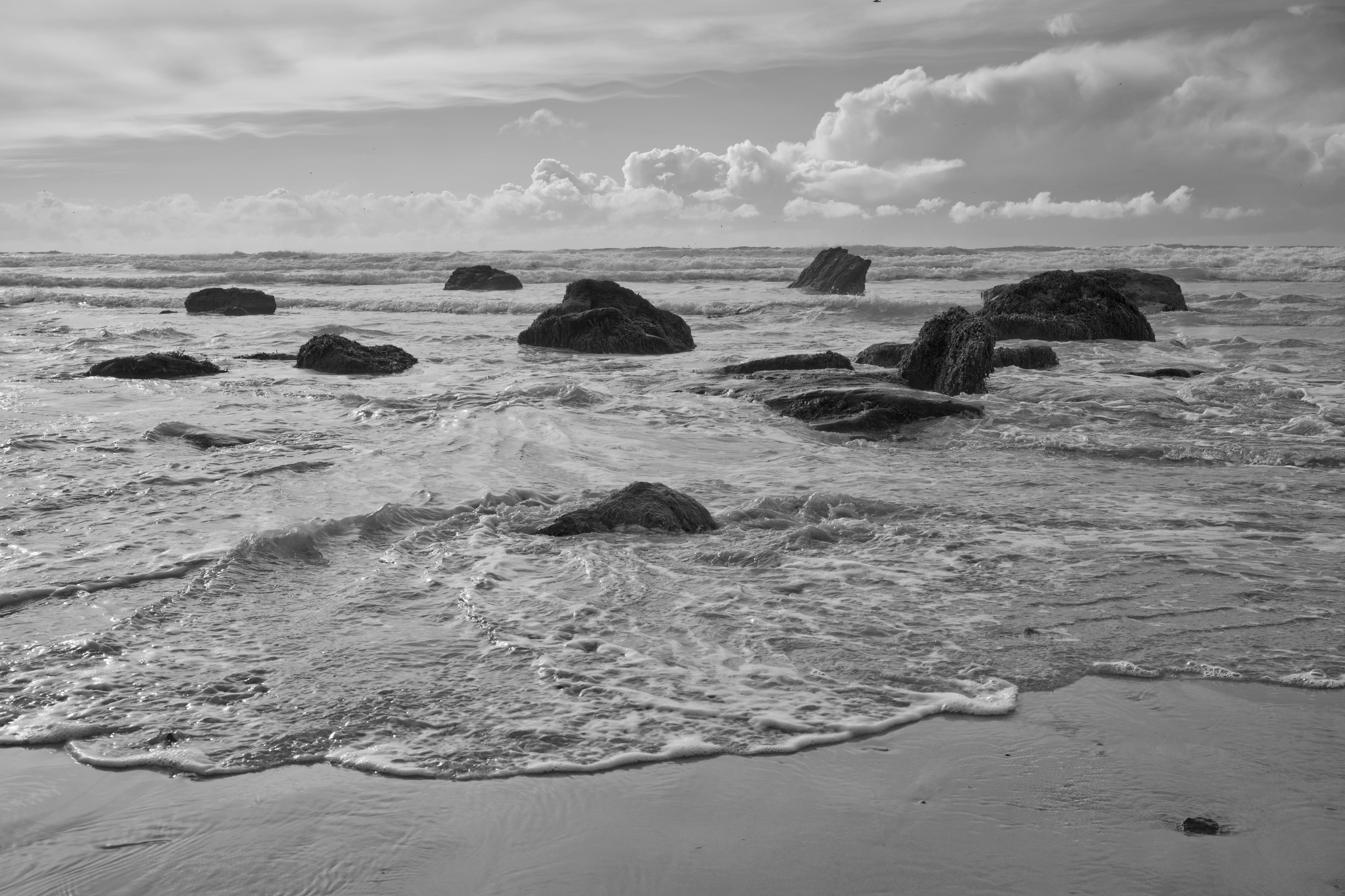 Black and white photo of rocks and waves at Watergate Bay Beach.