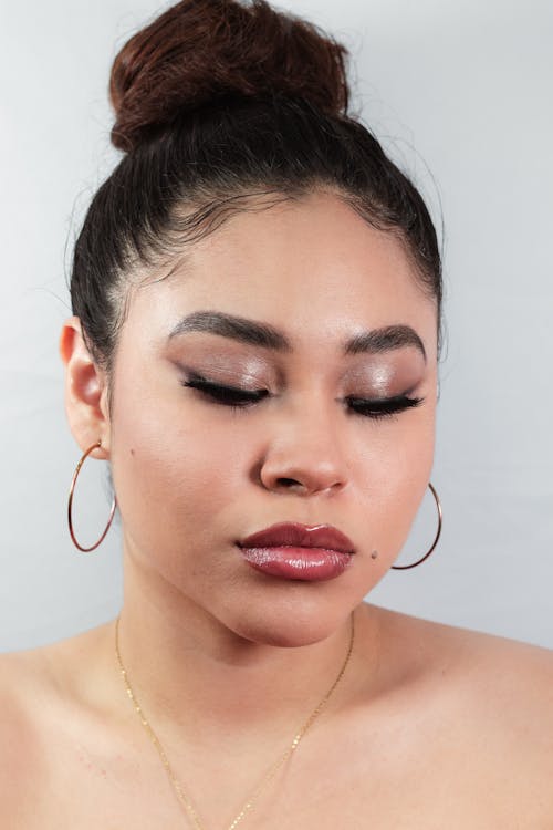 A woman with a gold hoop earring and a black top