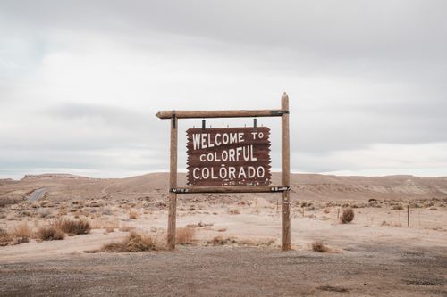 Free Desolate landscape in Colorado featuring a rustic welcome sign, ideal for travel themes. Stock Photo