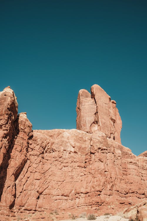 A person standing in front of a rock formation