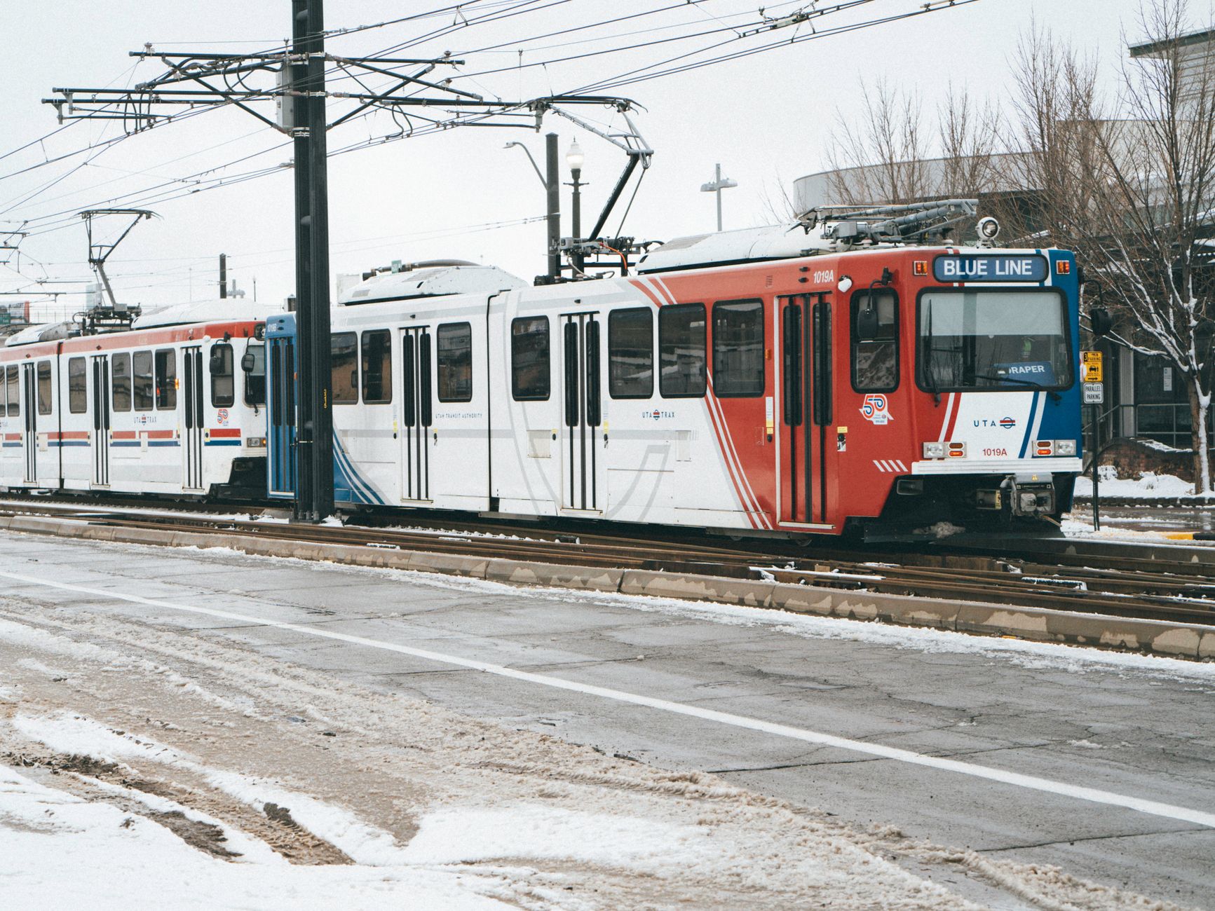 Salt Lake City's TRAX light rail train on a snowy winter day, showcasing urban public transport.