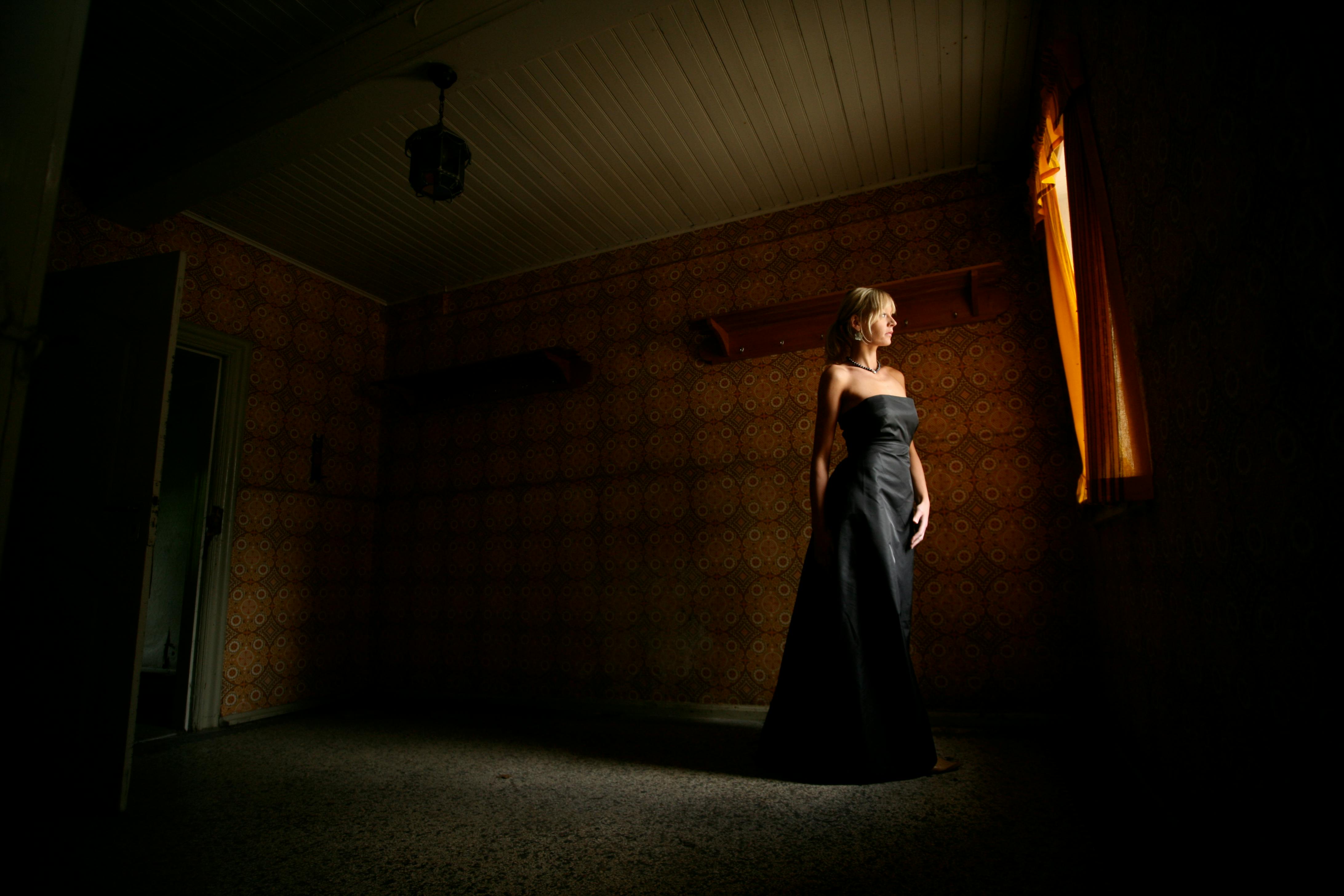 photography of woman in black dress in room