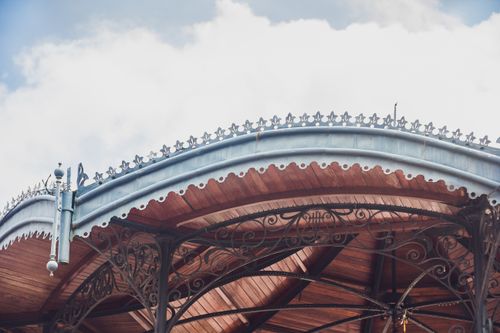 Free Elegant gazebo roof with intricate metalwork and natural wood texture against the sky. Stock Photo