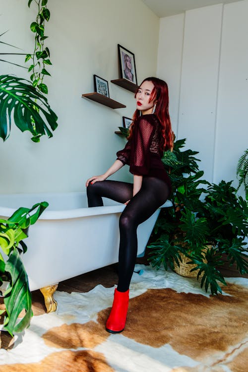 Free Model in Bodysuit Posing Sitting on Bathtub Stock Photo