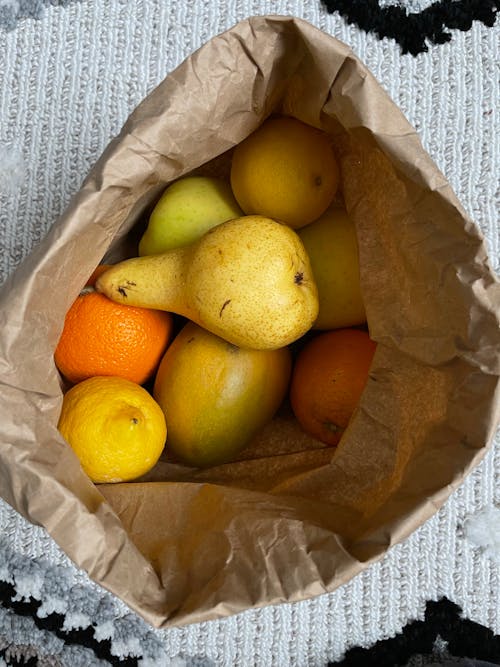 A brown paper bag filled with fruit