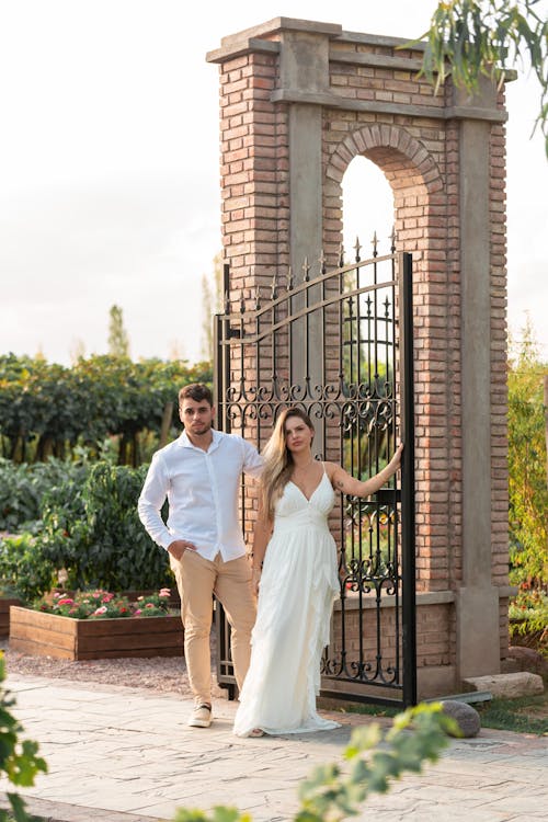 Married Couple by a Gate on Their Wedding Day