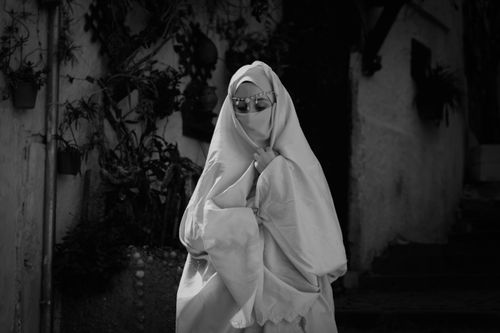 Free A woman in traditional attire with headscarf and sunglasses in Casbah, Algiers. Stock Photo