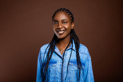 A smiling young woman with braids in her hair