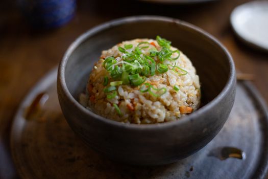 Close-up of a flavorful fried rice bowl garnished with fresh chives.