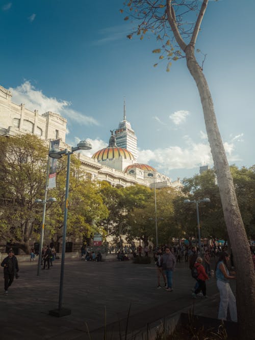 A city square with people walking around and a clock tower